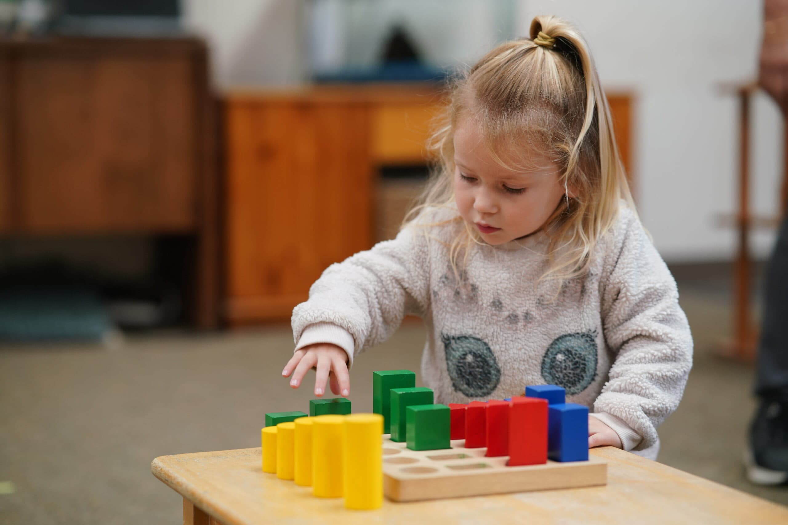 Toddler exploring Montessori materials at our school
